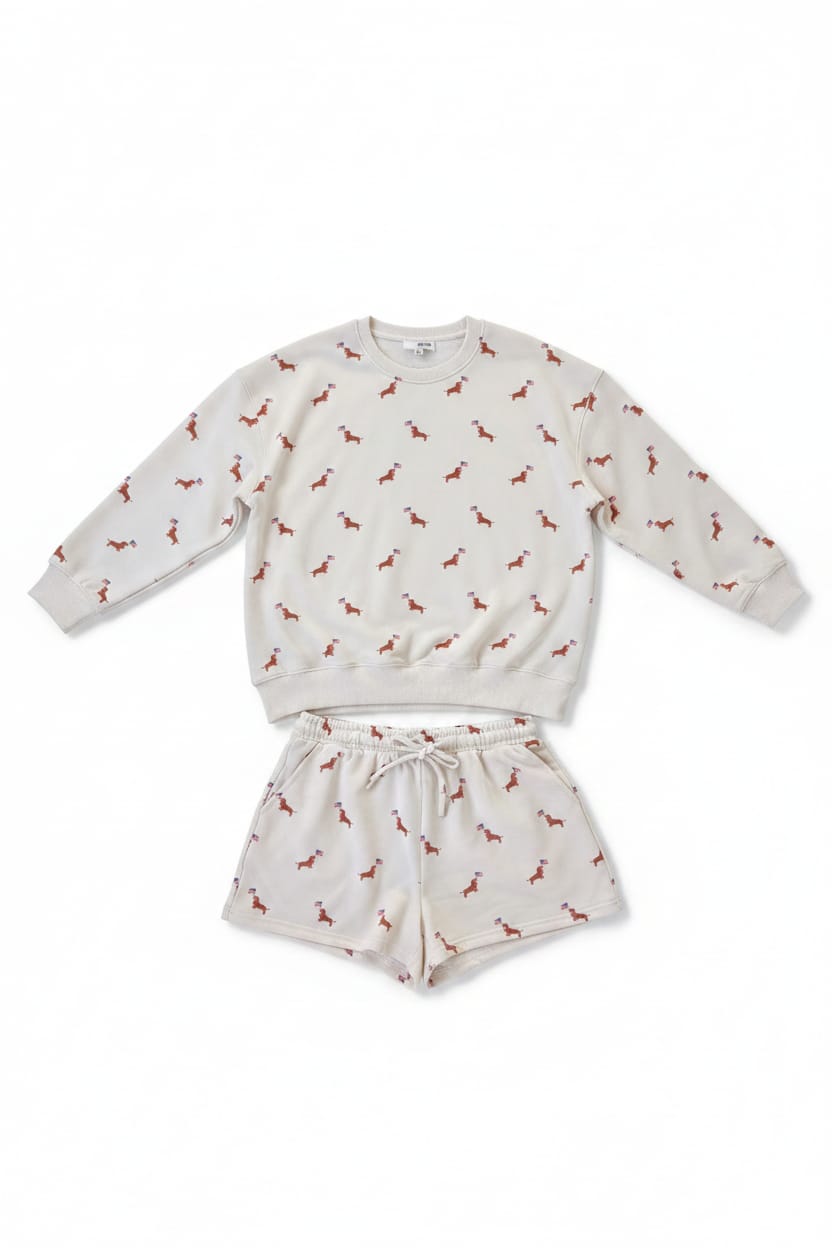 White sweatshirt and shorts set with small pattern on a hanger against a dark background